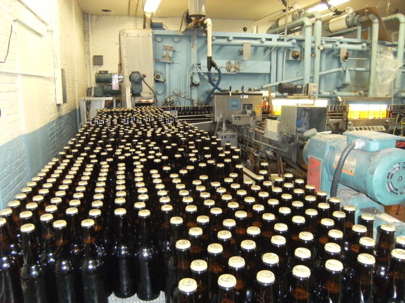 Bottles coming out of the pasturizer machine ready to get labeled.JPG